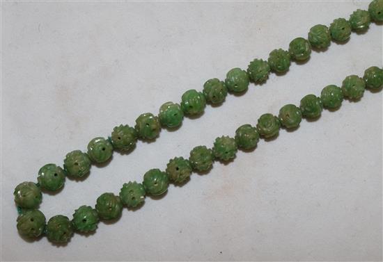 A Chinese carved jadeite bead necklace, early 20th century, total length 72.5cm, largest bead 9mm